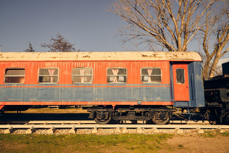 A beautifully aged train carriage against a tranquil outdoor backdrop, perfect for travel