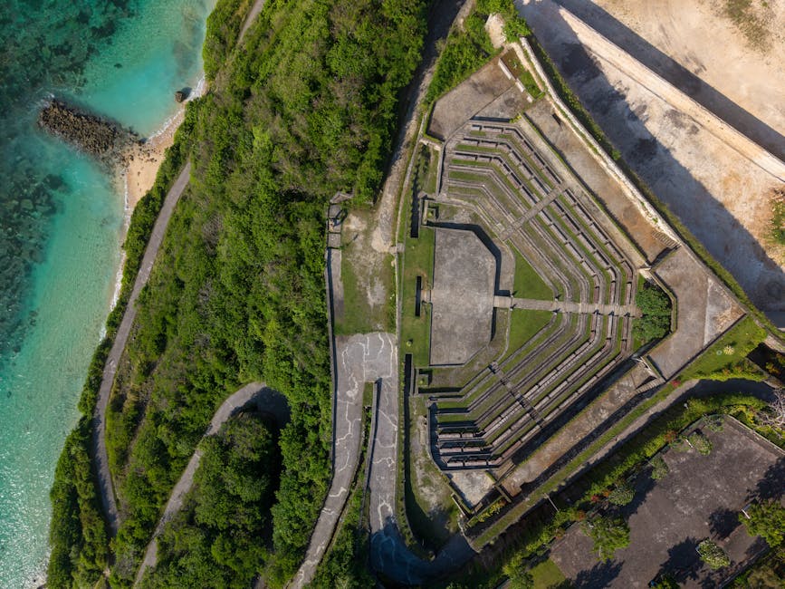 Aerial shot of lush greenery and amphitheater by the sea in Bali, Indonesia.