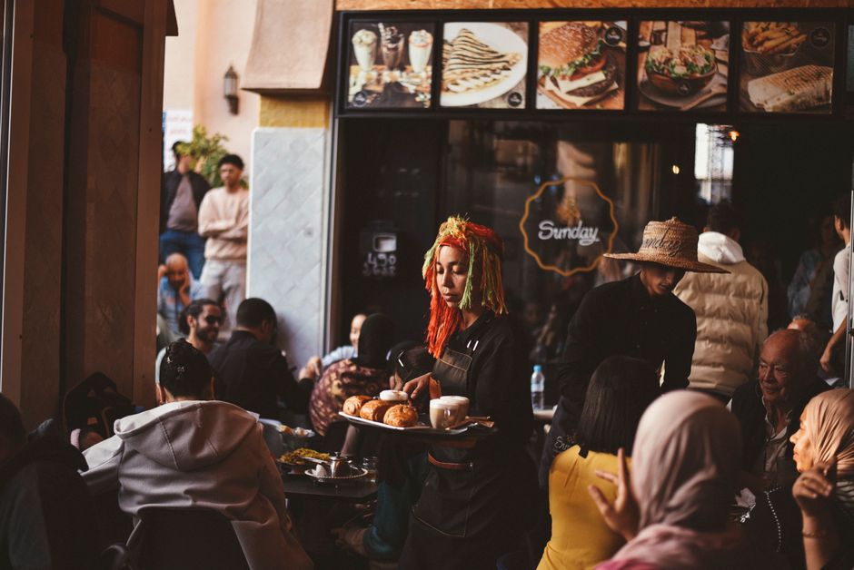 Vibrant cafe in Agadir with diverse crowd and lively atmosphere.