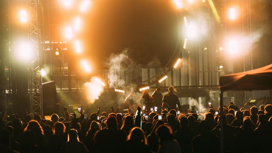 Captivating live concert scene with crowd and bright stage lights at night.