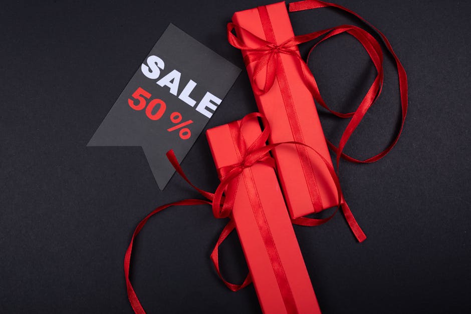 Red gift boxes with ribbons and a prominent 50% sale sign on black background.