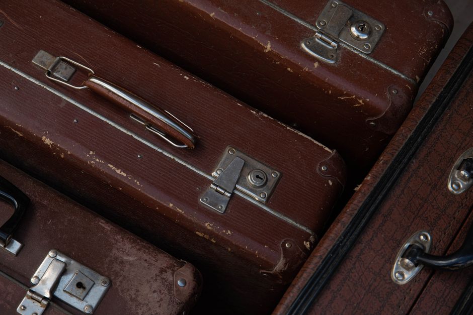 Close-up of vintage brown suitcases showing leather texture and metal locks.
