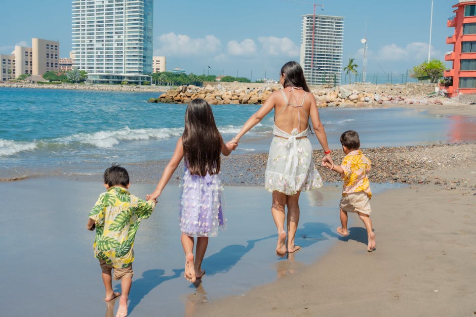 A family enjoys a sunny day walking on the beach, holding hands and creating memories.