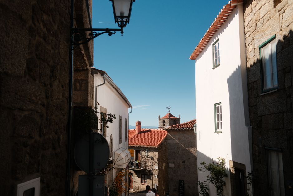 Discover the charm of a historic village in Portugal with stone architecture and blue sky.