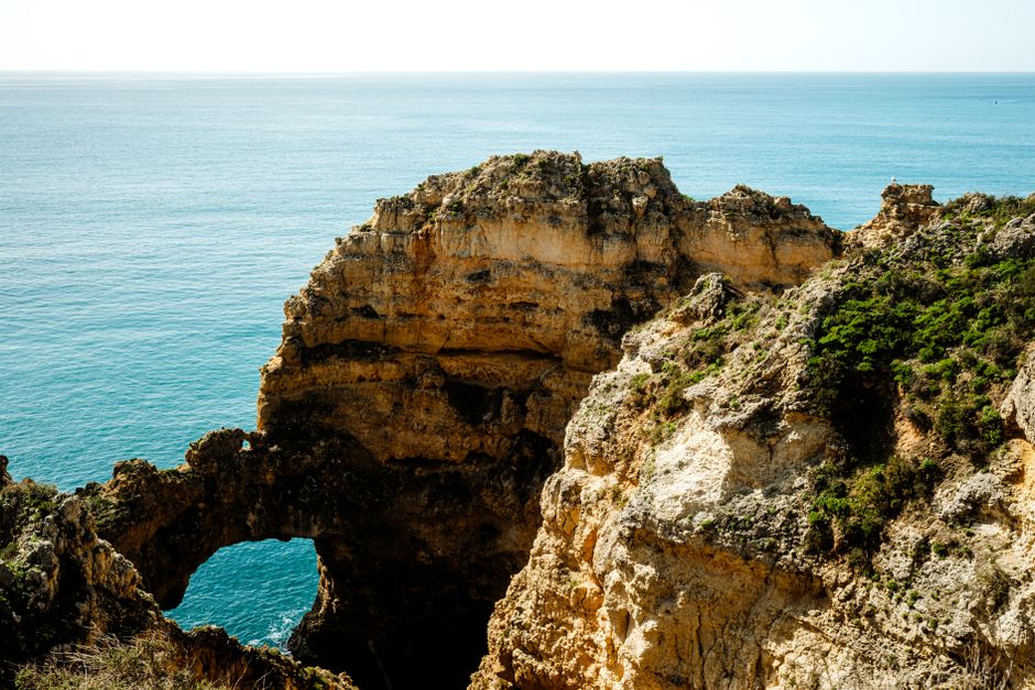 Breathtaking view of the coastal cliffs in Algarve, Portugal with clear blue water.