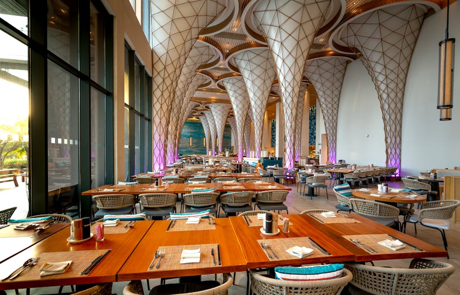 Spacious and stylish restaurant interior with unique ceiling design and arranged tables.