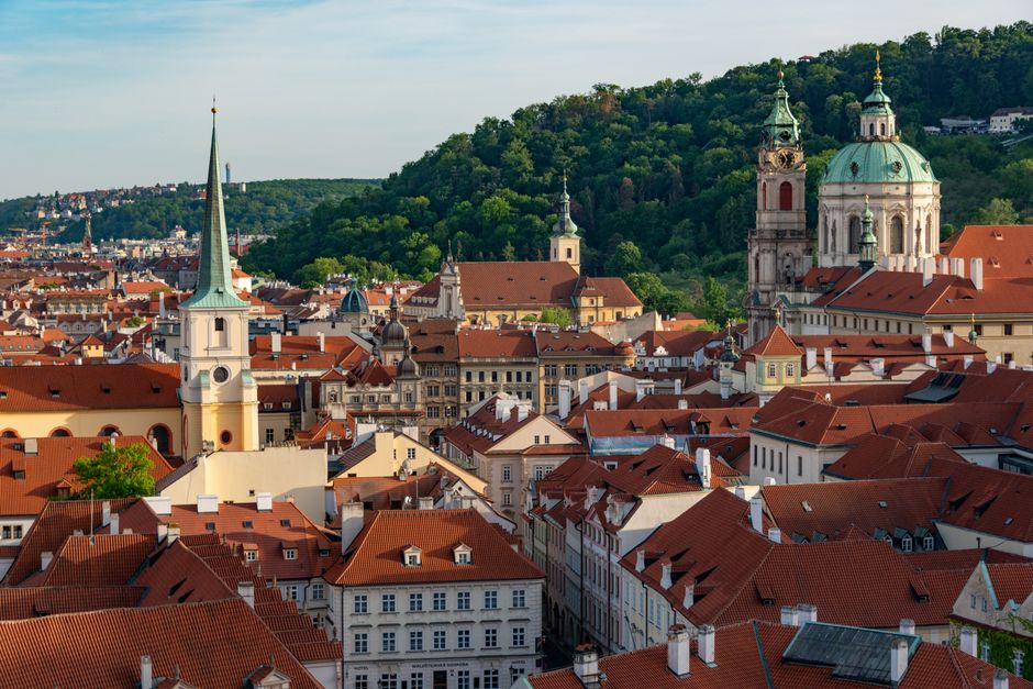 Aerial view of historical St. Nicholas Church and rooftops in Prague's old town.
