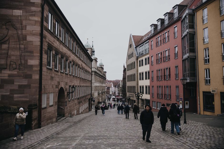 A cobblestone street in Nuremberg with classic German architecture and a bustling urban scene.