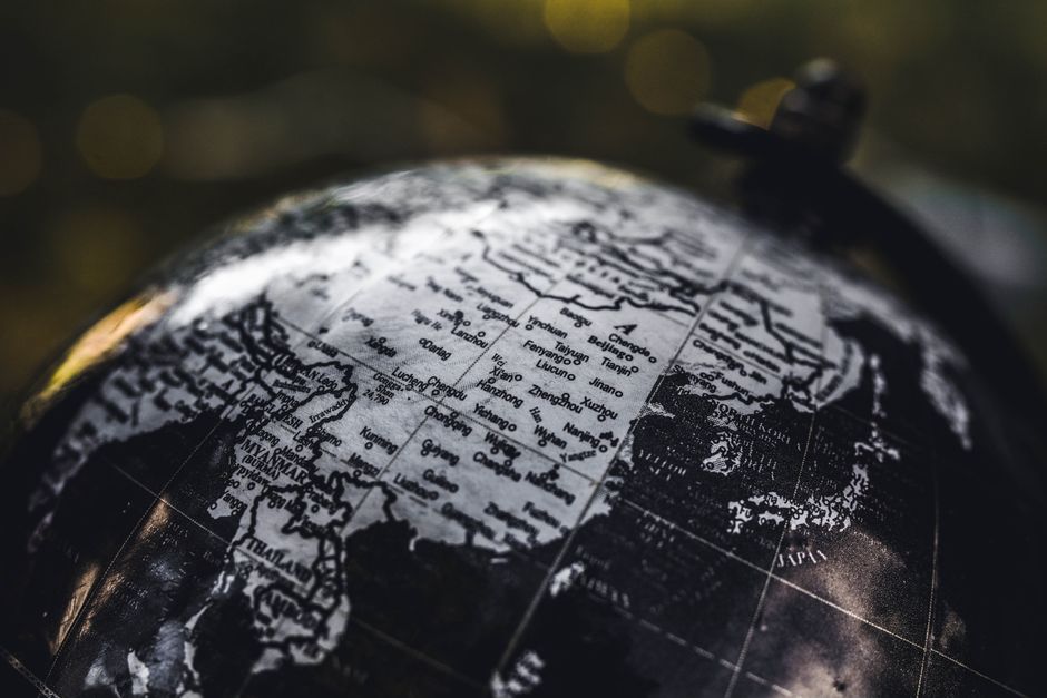 Detailed black and white close-up image of a globe focusing on Asia, highlighting geographical details.