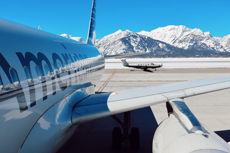 Airplanes parked at Jackson Hole Airport with snowy Teton mountains in the background.